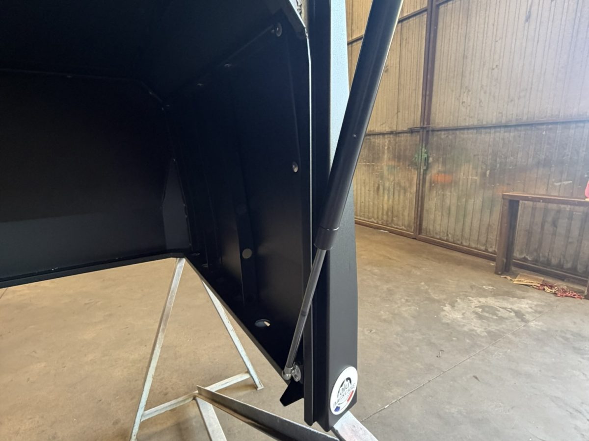 Vérin à gaz maintenant ouvert le panneau latéral d'un hard top Polaris Ranger